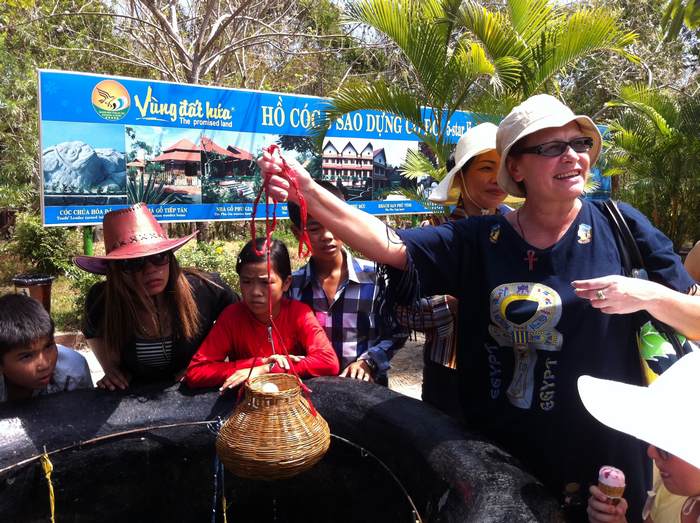 Du khách nước ngoài chụp hình lưu niệm với sản phẩm trứng luộc tại Khu du lịch  suối nước nóng Bình Châu.